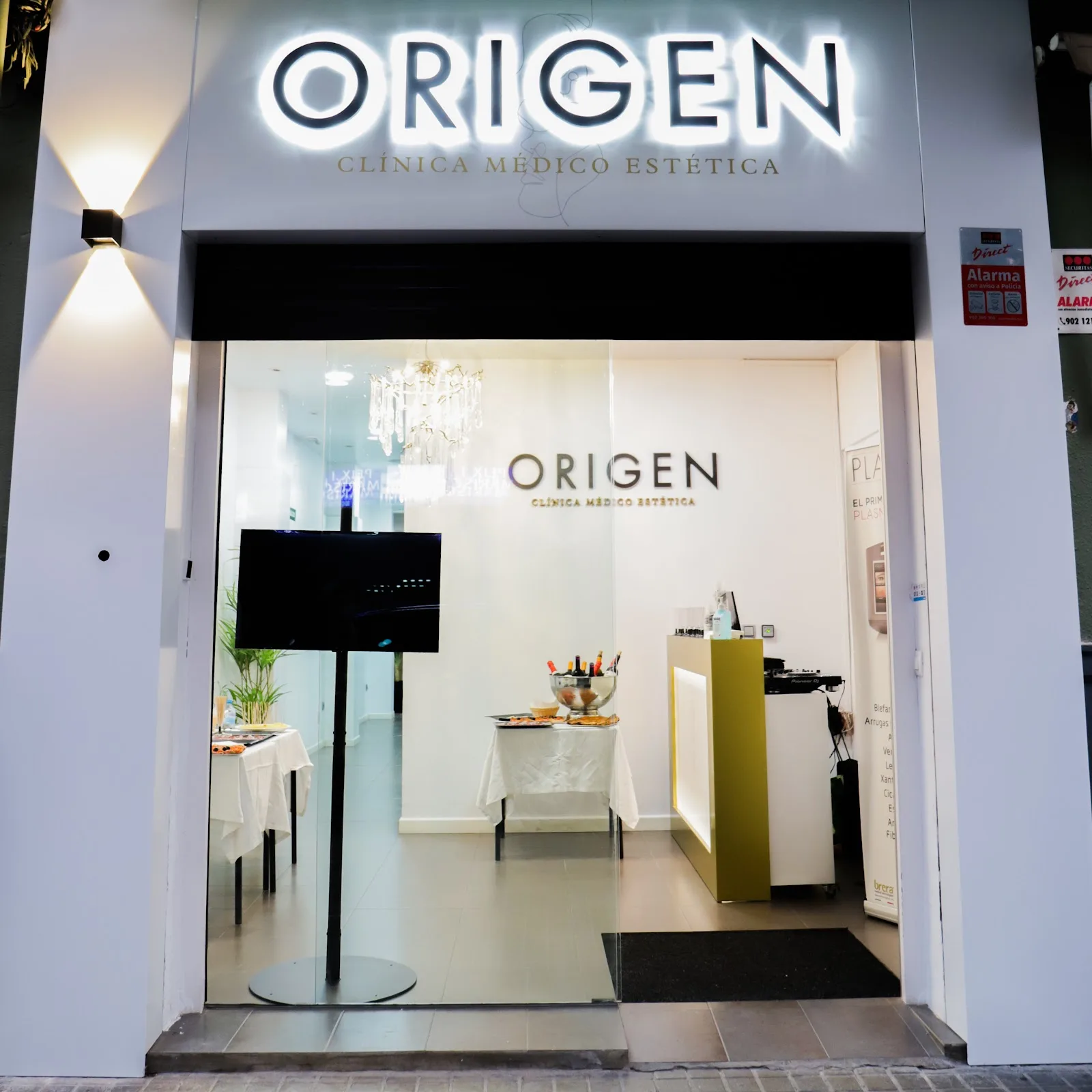 Entrada de ORIGEN en la calle de Císcar 30, con el rótulo iluminado